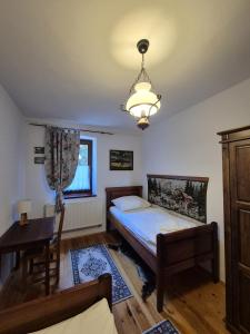 a bedroom with a bed and a desk and a lamp at Rábagyarmati Apartman in Rábagyarmat