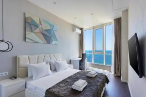 a hotel room with a bed and a large window at Sea Pearl 1Line in Odesa