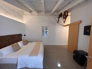 Un dormitorio con una cama y un televisor. en Smoix hotel, en Ciutadella