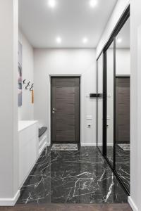a bathroom with black marble flooring and wooden doors at Sea Pearl 1Line in Odesa +26 photos