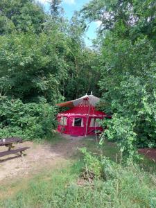 a red tent in the middle of a forest at CampSpirit in Biddinghuizen +4 photos