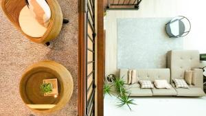 deux photos d'un salon avec un canapé et un miroir dans l'établissement Jeju Jebistay, à Sagye-ri