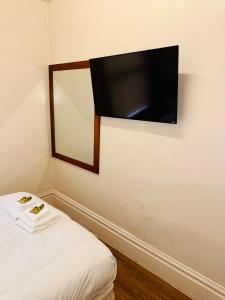 a flat screen tv hanging on a wall next to a bed at Riviera Hotel in San Francisco +7 photos