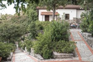 a garden in front of a house with bushes at Christoforos' Villa Sea View in Agios Ioannis Pelio
