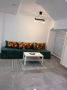 a living room with a green couch and a table at Bungalow Bahia Sur 33 in San Fernando