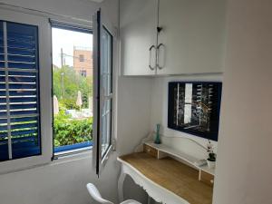 cocina con ventana, mesa y silla en APARTMENT L.A., en Tivat