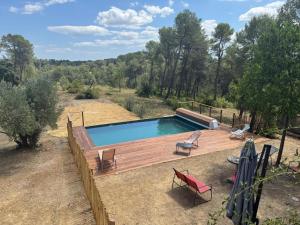 a swimming pool with a wooden deck and chairs at Villa 13 personnes - 1 hectare de parc naturel - piscine in Saint-Clément-de-Rivière
