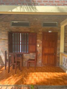 Habitación con mesa, sillas y pared de ladrillo. en Bungalow COCO CHILL PQ, en Phu Quoc