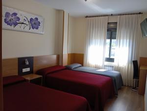 a hotel room with two beds and a window at Peregrino in Pontevedra