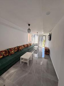 a living room with a green couch and a table at Bungalow Bahia Sur 33 in San Fernando