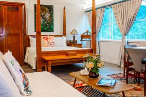 a living room with a bed and a table and a room at Sinurambi Cottage Rental in Penampang