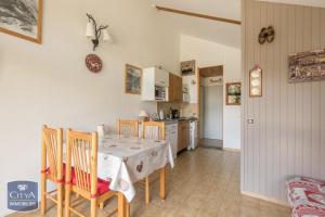 a kitchen and dining room with a table and chairs at Appart Tallas Pieds Des Pistes in Ancelle