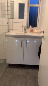 a bathroom with a white sink and a mirror at Cozy New Apartment in Vejle City Center in Vejle
