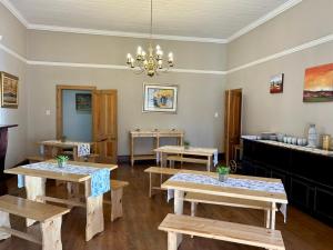 a dining room with wooden tables and a chandelier at Lindela House in Kokstad