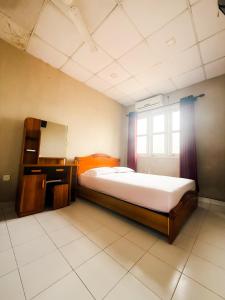 a bedroom with a bed and a desk and a window at Riverside Hotel Colombo in Katunayaka