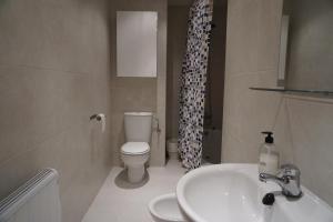 a bathroom with a white sink and a toilet at El Vino y sus Musas Clavijo in Clavijo +25 photos