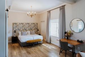 a bedroom with a bed and a desk and a mirror at Laborie Estate in Paarl +70 photos