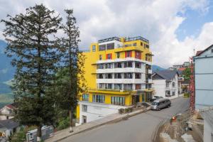 un bâtiment jaune au bord d'une rue dans l'établissement Lestar Hotel Sapa, à Sa Pa