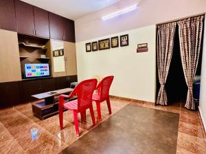 a room with two red chairs and a desk at Divine Homestay by EDAC in Chidambaram