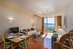 Una sala de estar con una cama, una mesa y sillas. en Orizzonte Blu with Terrace by Wonderful Italy, en Santa Margherita Ligure