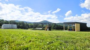 a large field with a building and a field of grass at Zacisze w Karkonoszach in Karpacz