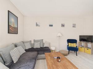un salon avec un canapé, une table et une télévision dans l'établissement 100m de la plage - Maison pour 4 à St Hilaire, à Les Bussolleries