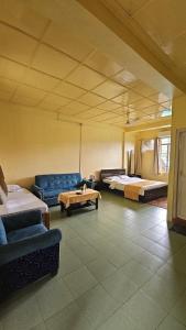 Habitación con 2 camas, sofá y mesa. en Vestawood Orchid Resort, Dawki Meghalaya, en Dawki 4 fotos más