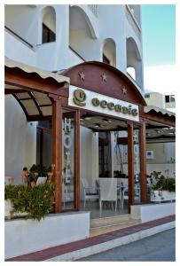 a restaurant with tables and chairs in front of a building at Oceanis Hotel in Karpathos