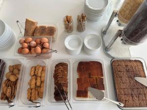 a table topped with trays of different types of food at Oceanis Hotel in Karpathos