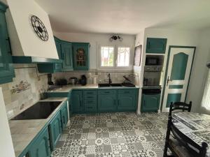 a kitchen with green cabinets and a tile floor at Villa VERDOLINE in Digne-les-Bains
