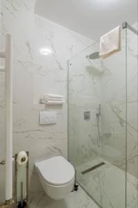 a white bathroom with a toilet and a shower at De Silva Apartament1 in Mamaia +17 photos