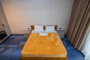 a small bedroom with a bed with two pillows at De Silva Apartament1 in Mamaia