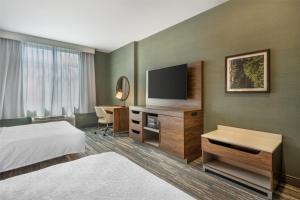 a hotel room with a bed and a flat screen tv at Hampton Inn and Suites Coeur d'Alene in Coeur d'Alene