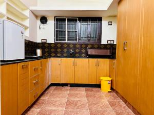 a kitchen with wooden cabinets and a window at Divine Homestay by EDAC in Chidambaram