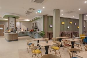 a restaurant with tables and chairs and a counter at Hampton By Hilton Dresden City Centre in Dresden