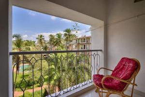 a balcony with a chair and a view of a resort at Luxury 2bhk Apartment with Swimming Pool in Candolim in Candolim