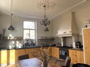 アッカースロートにあるVilla free standing 25 min Amsterdam 10 min beachのキッチン(テーブル、シャンデリア付)