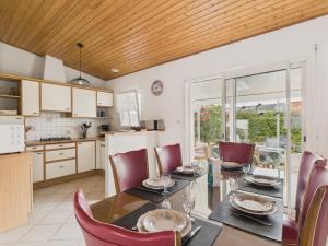 a kitchen and dining room with a table and chairs at Jardin et véranda - Maison 4 adultes 2 enfants in Saint-Hilaire-de-Riez +19 photos