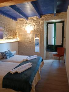 a bedroom with two beds and a red chair at Noelmar II Combarro in Combarro