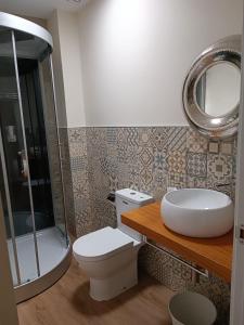 a bathroom with a toilet and a sink and a mirror at Noelmar II Combarro in Combarro +14 photos