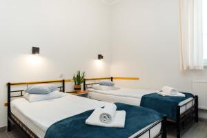a room with three beds with towels on them at Arcus Premium Hostel in Warsaw