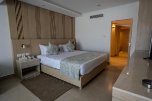 a bedroom with a large bed with a night stand at Ecotel Dahab Bay View Resort in Dahab +132 photos