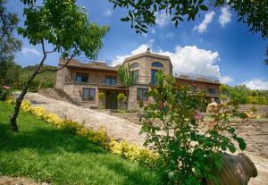 an old stone house with a garden in front of it at Assos Dionysos Special Class Hotel Adults Only 12 years in Behramkale