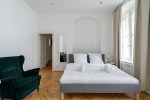 Un dormitorio con una cama y una silla verde. en Historic Heart Apartment Vienna, en Viena