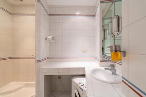 y baño con lavabo, bañera y lavadora. en Historic Heart Apartment Vienna, en Viena