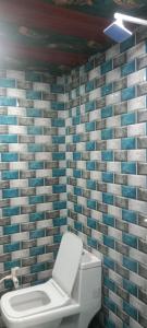 a toilet in a bathroom with blue and white tiles at Little KANHA ji PG 10 Room82798s58346 Hotal, also taxi and Activa rent in Mathura