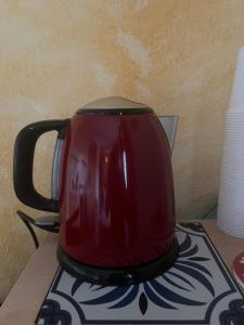 a red tea kettle sitting on top of a table at Le Fontanelle Apartment in Siniscola