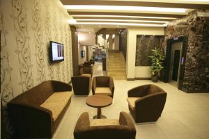 a lobby with chairs and a table and stairs at Hotel Guven in Urfa