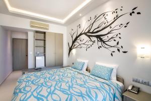 a bedroom with a tree mural on the wall at Oceanis Hotel in Karpathos