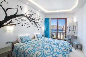 a bedroom with a bed with a tree mural on the wall at Oceanis Hotel in Karpathos